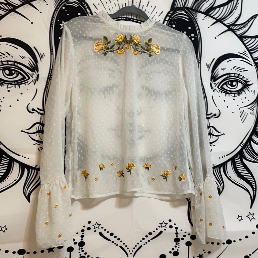 A mesh floral shirt with bell sleeves